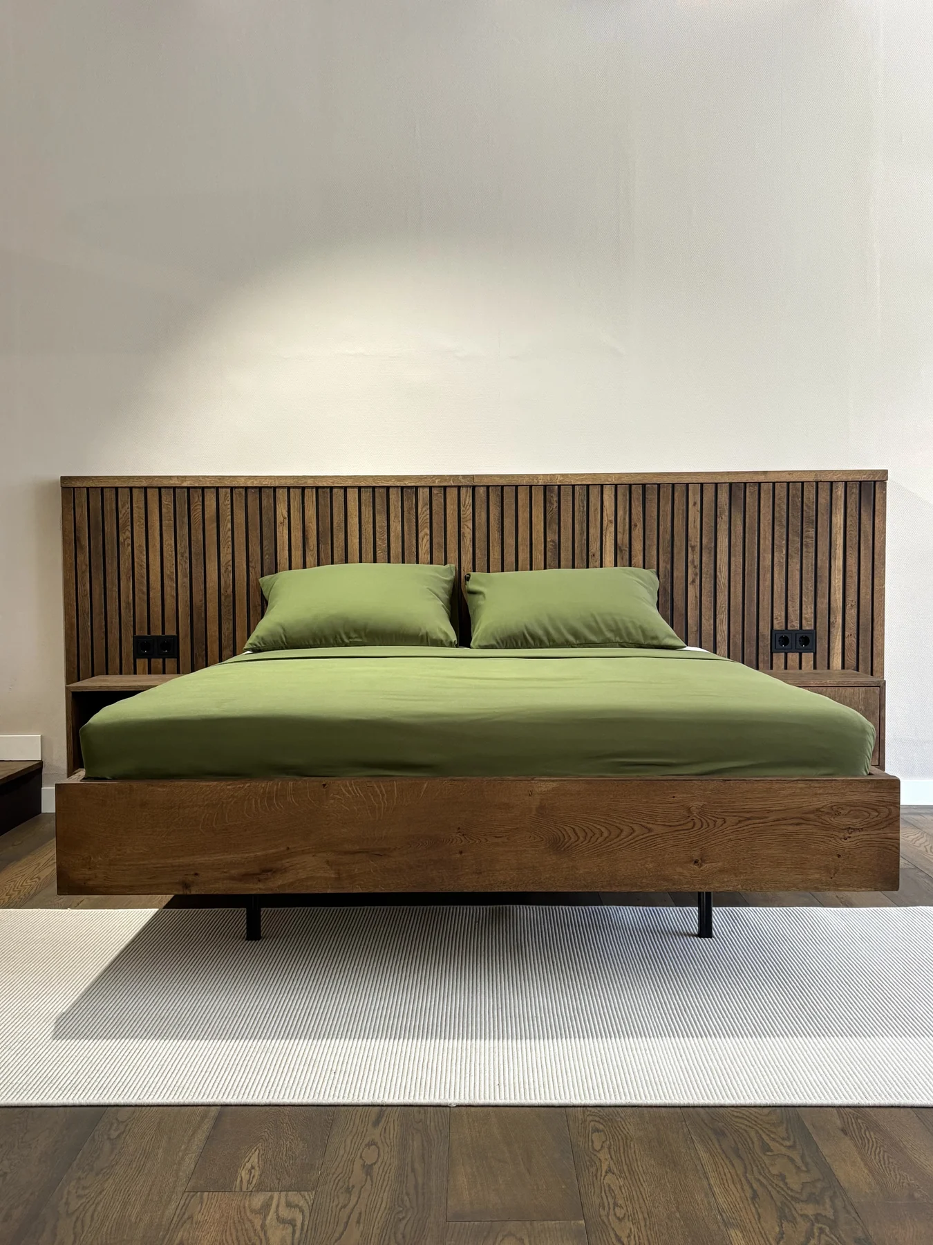 Handgemaakt houten bed met groen beddengoed